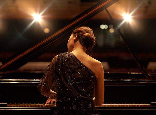 Konserttisalin hyvä akustiikka suuria hetkiä varten Konserttisalin äänenvaimennus parantaa akustiikkaa – pianisti suurena hetkenään soittamassa
