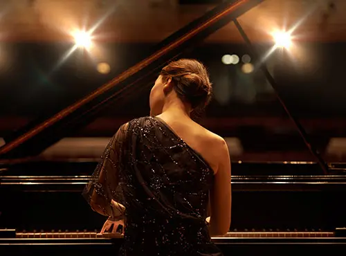 Konserttisalin äänenvaimennus parantaa akustiikkaa – pianisti suurena hetkenään soittamassa
